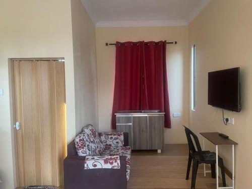 Tumpat瓦恩旅馆的带沙发和红色窗帘的客厅