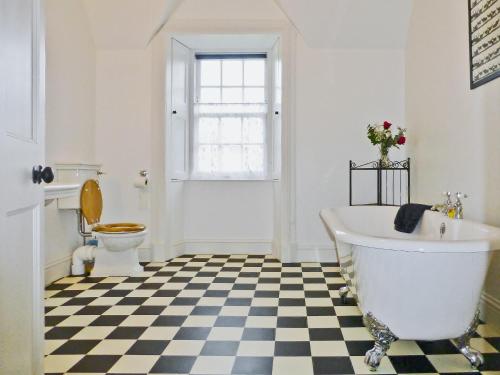 Kilmartin法克托乡村别墅的一间带白色浴缸和 ⁇ 格地板的浴室