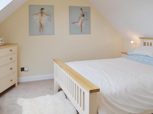 MatfieldDairy Cottage的卧室配有一张床,墙上挂有两张照片