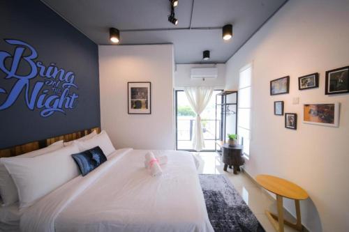 峇六拜Pondok Tok Bee的卧室配有白色床,墙上有标志