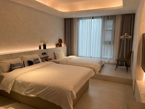 西安忆宿石玖设计师酒店(西安钟鼓楼回民街店)的酒店客房设有两张床和窗户。