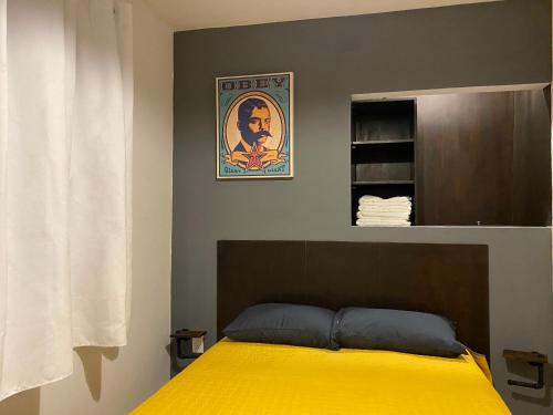 墨西哥城Cozy Condesa的一间卧室配有一张黄色毯子床