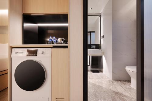 上海大都会海逸公寓的一间带洗衣机和水槽的浴室