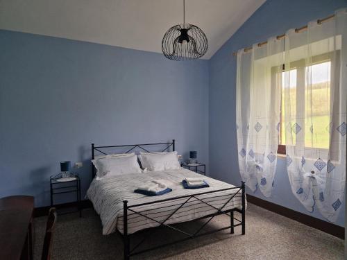 圣奎里科-多尔恰罗瑟洛农场酒店的蓝色的卧室设有床和窗户
