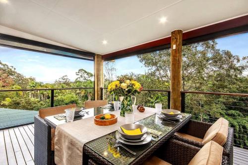 NinderryNoosa hinterland acreage close to the beach的甲板上配有桌椅的用餐室