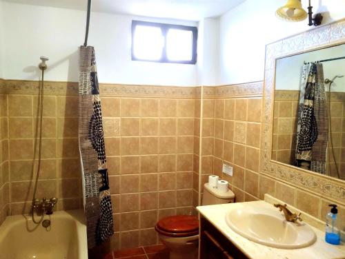 隆达La Casita de Piedra的一间带水槽、卫生间和镜子的浴室