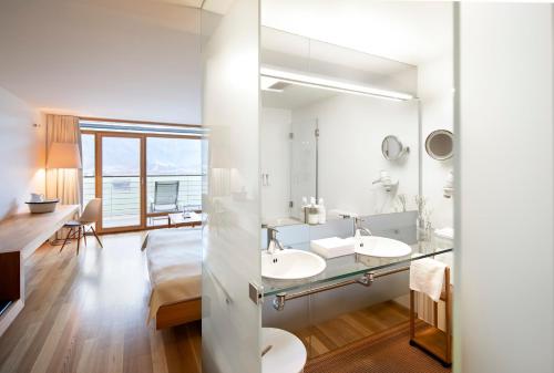 贝曹Hotel Post Bezau的浴室设有2个水槽和镜子