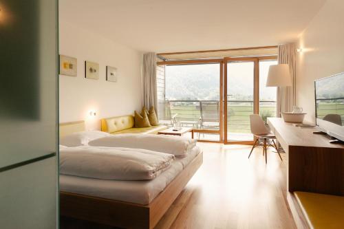 贝曹Hotel Post Bezau的配有一张床、一张书桌和一扇窗户的酒店客房