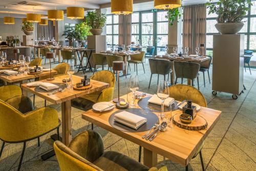 奥拉涅沃德Parkhotel Tjaarda的餐厅设有木桌和黄色椅子