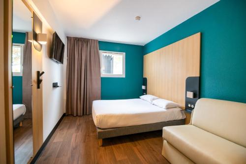 梅里尼亚克B&B HOTEL Bordeaux Mérignac Aéroport的酒店客房,配有床和沙发