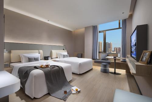 广州诗贝酒店的酒店客房设有两张床和一台平面电视。