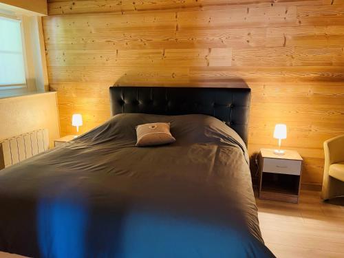 克松吕-隆日梅※ Résidence POMME DE PIN - Terrasse - Nature ※的一间卧室配有一张带木墙的大床