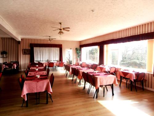 桑当艾塔维亚酒店的一间设有红色桌椅和窗户的用餐室