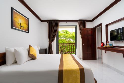 会安Haemer Villa Hoi An的一间带大床的卧室和一个阳台