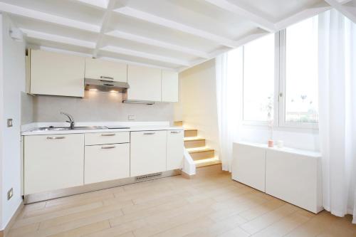 卡托利卡Villa Fiorita的厨房配有白色橱柜、水槽和窗户。