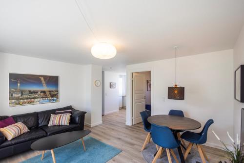 孔恩斯灵比Central Lyngby Apartments的客厅配有黑色沙发和桌子