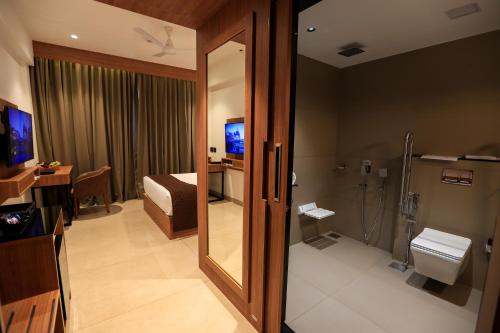 苏丹巴特利Hotel Saffron Wayanad的客房设有带淋浴和卫生间的浴室。
