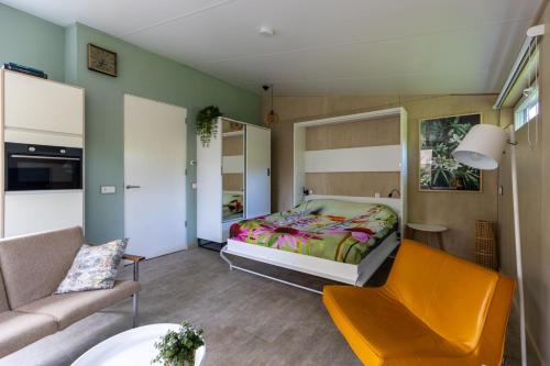 弗利辛恩Vrijburgstraat 10的一间卧室配有一张床、一张沙发和一把椅子