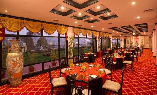 乌提宝石公园乌蒂酒店的餐厅设有桌椅和大窗户。