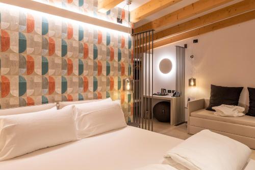 托里德尔贝纳科Relais Limonaia - Suites & Garden SPA的卧室配有白色的床和沙发
