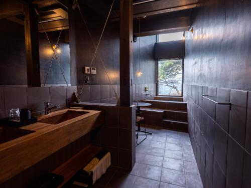小滨市sea-auberge shitsumi 海のオーベルジュ志積的一间带水槽和浴缸的浴室以及窗户。