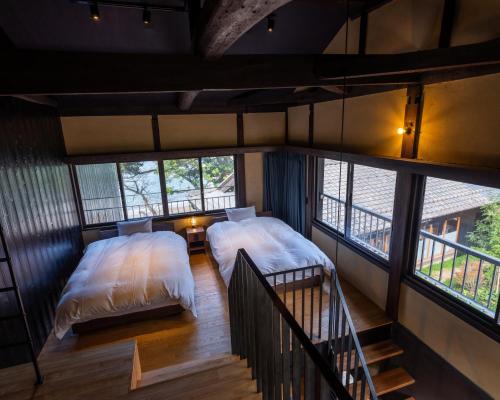 小滨市sea-auberge shitsumi 海のオーベルジュ志積的小型客房设有2张床和窗户。