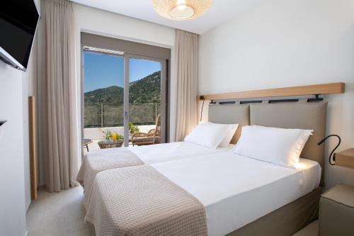 卡拉米锡Inorato - Luxury Villas with Private Swimming Pool的一间卧室设有一张床和一个大窗户