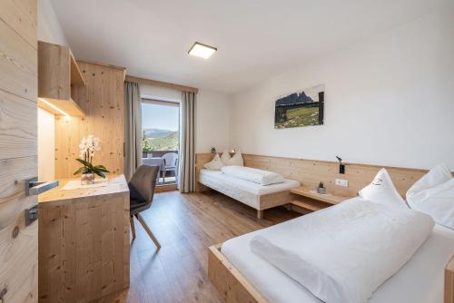 卡斯特尔罗托Haus Pötzes的酒店客房带两张床、书桌以及一间客房。
