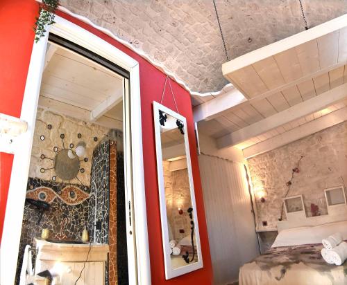 普蒂尼亚诺L'Angolo di Gaudì, casa Milà的一间带镜子和红色墙壁的卧室