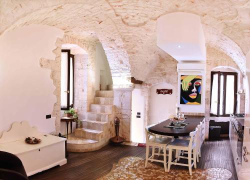 普蒂尼亚诺L'Angolo di Gaudì, casa Milà的客厅配有桌椅和石墙