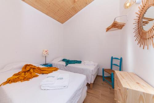 布德恩斯B54 - Casa Azul in Burgau的客房设有两张床、一张桌子和镜子