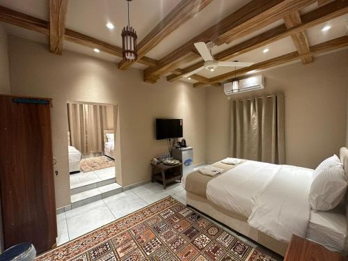 阿尔哈姆拉Al Hamra Mountain View的一间卧室配有一张大床和一台电视。