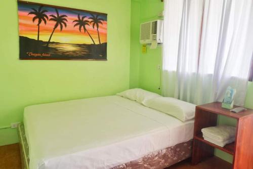 AbuPuesta del sol Beach Bungalows and Restobar的一间卧室设有床铺和种有棕榈树的窗户。