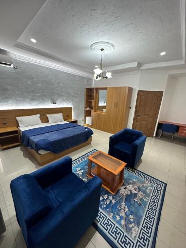 布拉柴维尔Hotel de l'Aeroport的一间卧室配有一张床和两张蓝色椅子