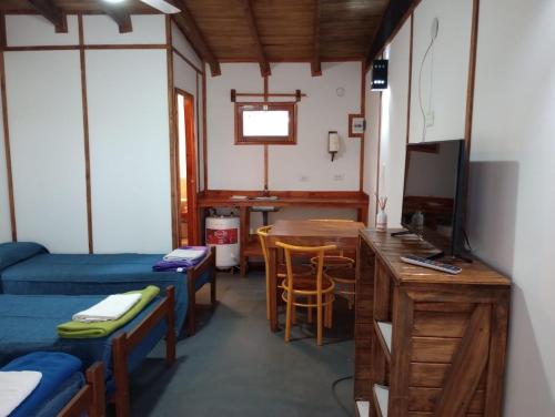 UsnoTierra Yacampis264的客房设有两张床、一张桌子和电视。