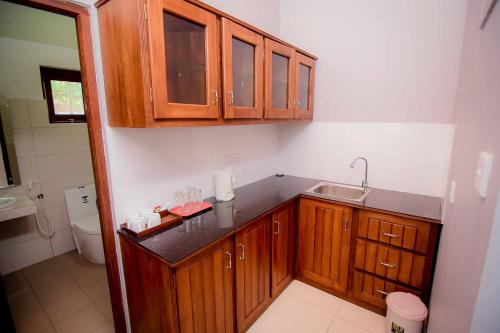 卡图纳耶克机场别墅酒店的一个带木制橱柜和水槽的厨房