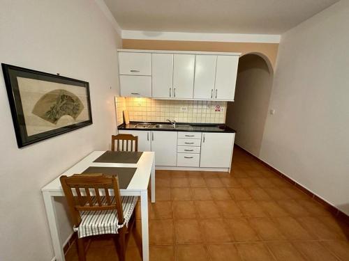 茨里克韦尼察Ivana apartman 3的厨房配有白色橱柜和桌椅
