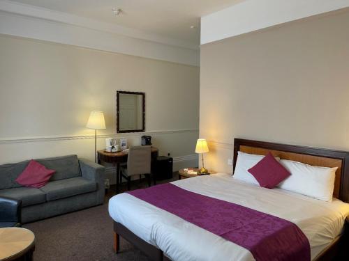 斯卡伯勒大不列颠斯卡伯勒豪华酒店的酒店客房带一张大床和一把椅子