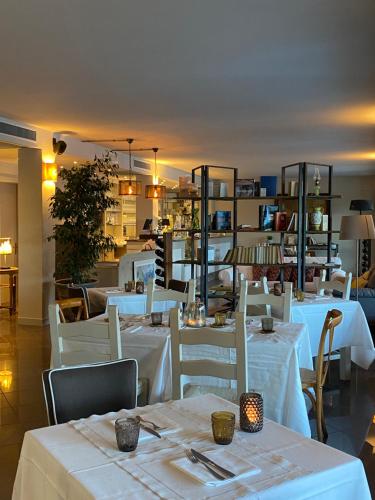 利莫内-苏尔加达Residence Dalco Suites & Apartments的一间设有白色桌子和白色椅子的餐厅
