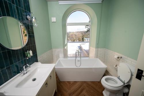 梅奈布里奇Victoria Hotel by Chef & Brewer Collection的一间带水槽、浴缸和卫生间的浴室