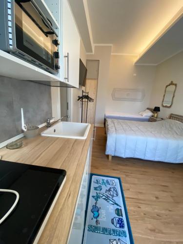 福洛尼卡Camera via Roma的一个带水槽的厨房和一张位于客房内的床
