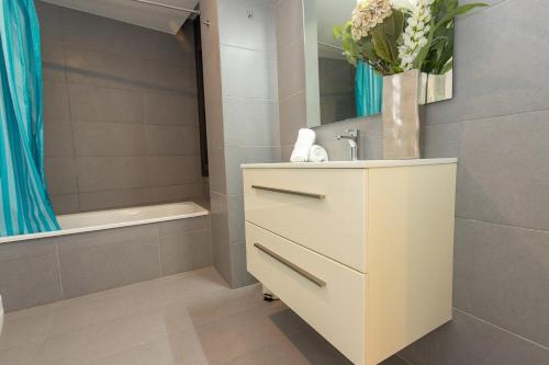 罗萨斯RNET - Casa 4 - Vista Mar Almadrava Roses的浴室配有盥洗盆和浴缸。