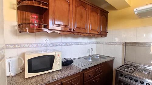 明德卢Apartamento acolhedor com vista para o Monte Cara的厨房配有微波炉和水槽