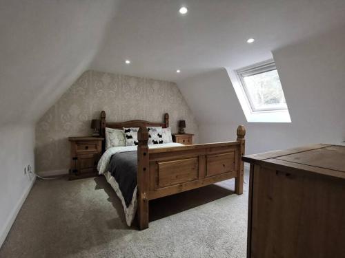 亚历山德里亚Historic cottage next to loch lomond Luss的一间卧室设有一张木床和一个窗户。