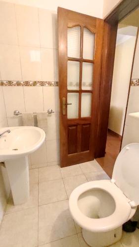 明德卢Apartamento acolhedor com vista para o Monte Cara的一间带卫生间和水槽的浴室