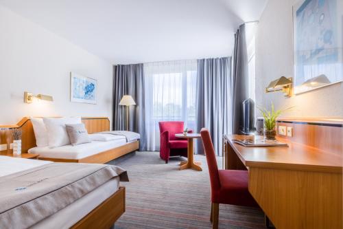 索林根Select Hotel Solingen的酒店客房配有一张床、一张沙发和一张书桌。