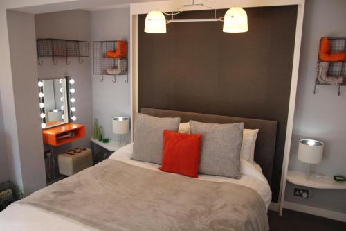 赫尔The Light Room at no.7的一间卧室配有一张大床,提供橙色和灰色的枕头