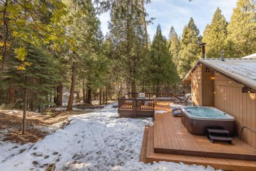 奥克赫斯特Red Rock Falls Cabin, 8 miles from Yosemite South Gate, with trailhead, Game Room and HotTub的雪地木甲板上的热水浴池
