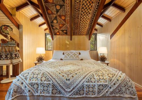 NinderryThe Forest Buré - Fijian Hinterland Retreat的卧室配有一张床铺,位于带木墙的房间内