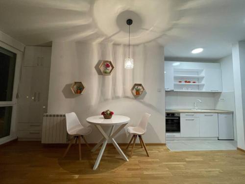 诺维萨德Vera's place的厨房配有桌子、两把椅子和一张桌子